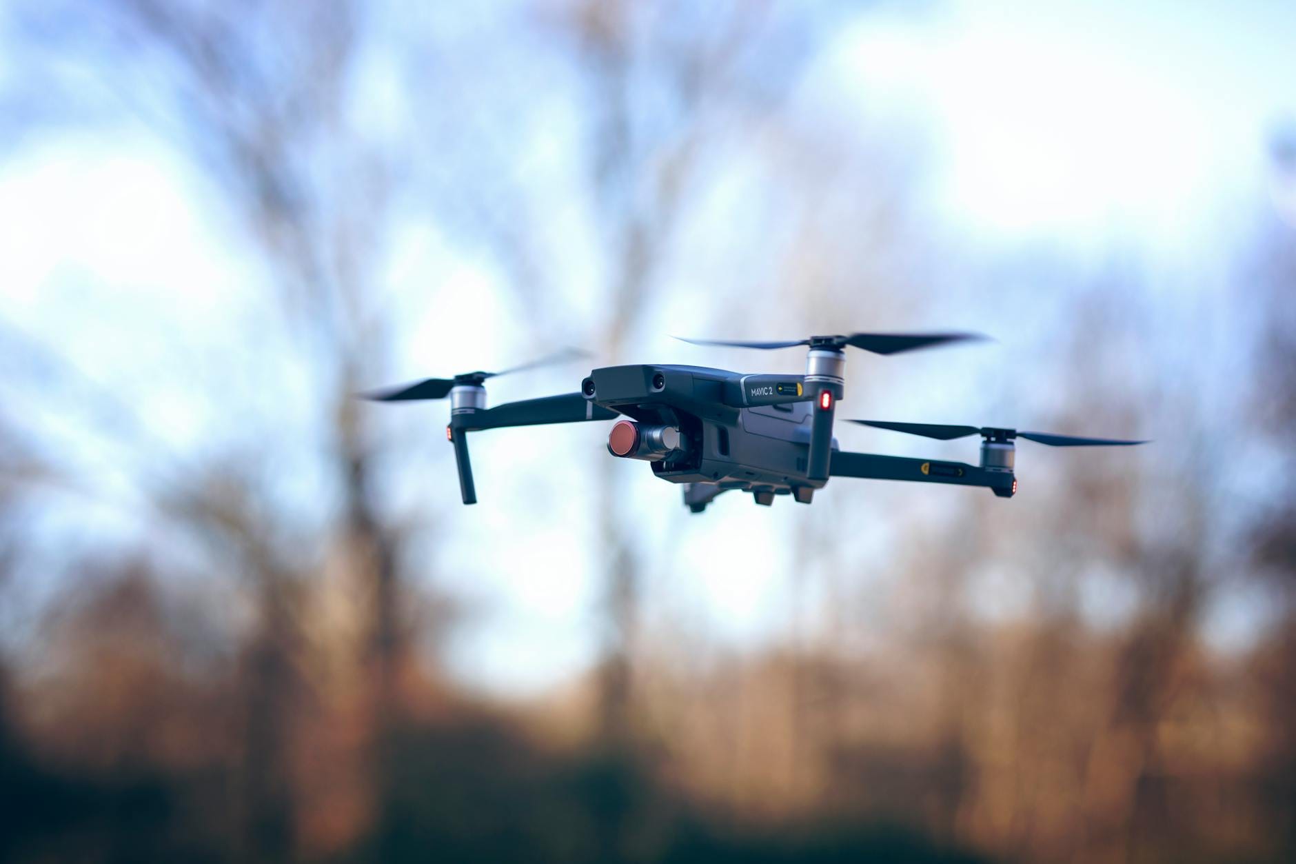 Dron w locie na tle jasnego dziennego nieba