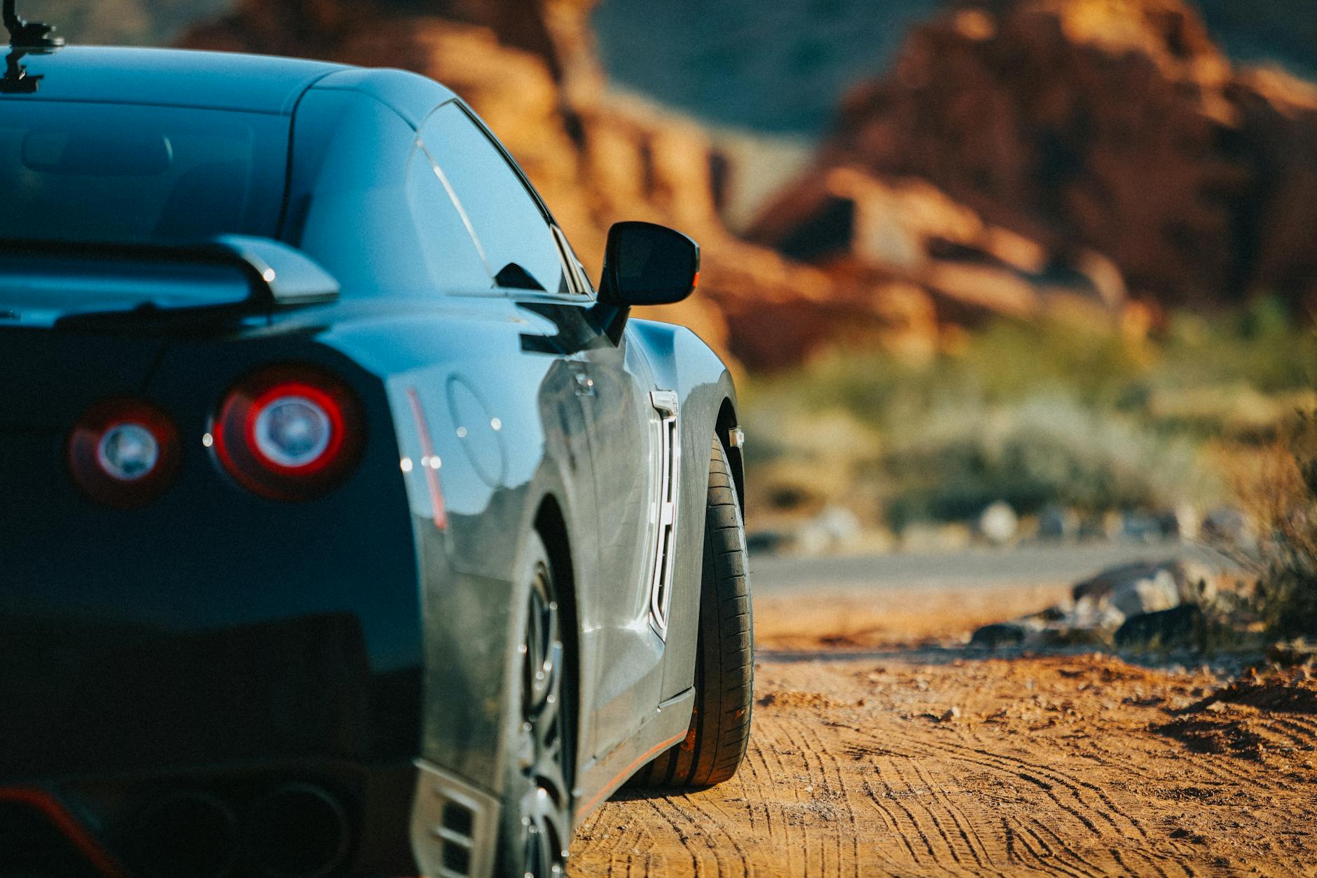Czarne Porsche Cayman od tyłu na tle pustyni w Nevadzie Czarne Porsche Cayman od tyłu na tle pustyni w Nevadzie