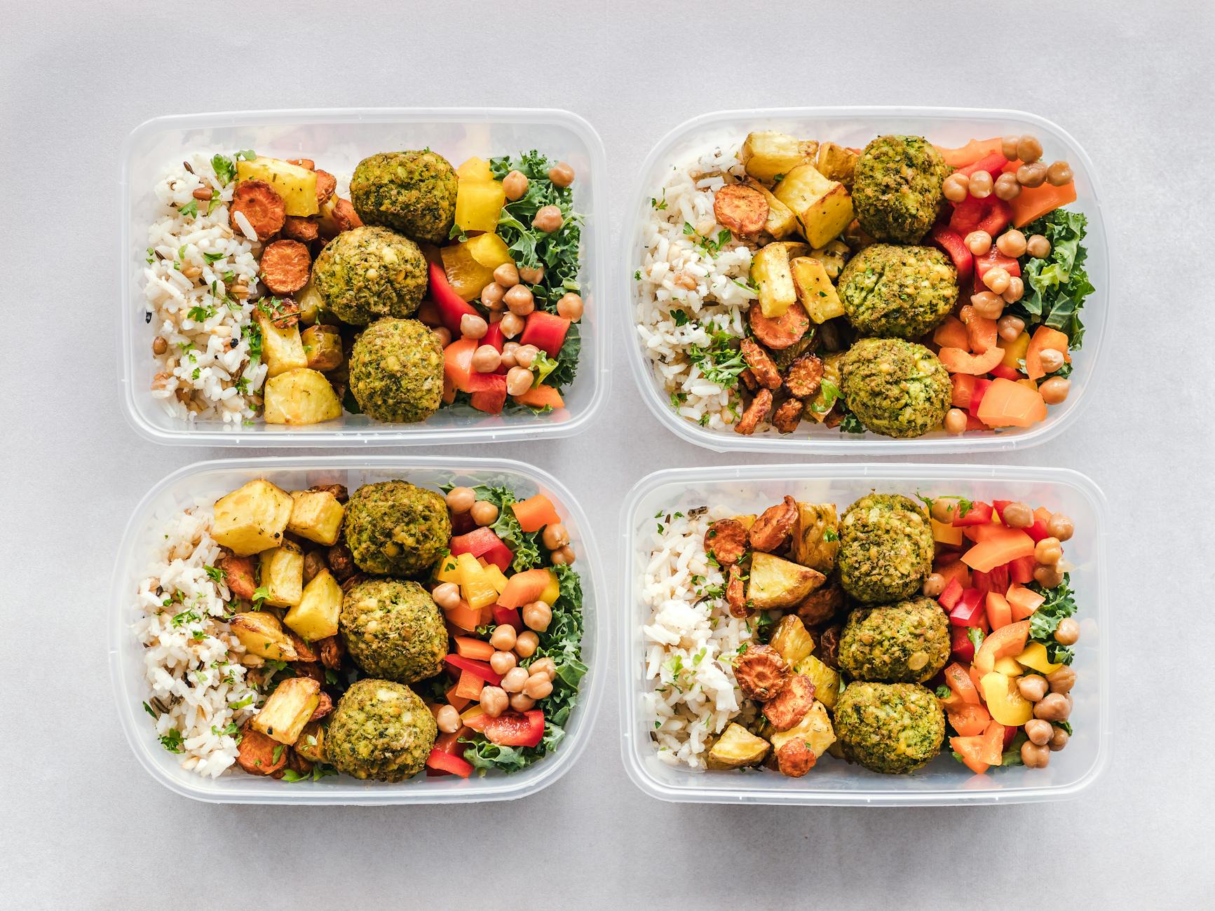 Pojemniki z kolorowym wegańskim meal prepem z falafelem i warzywami