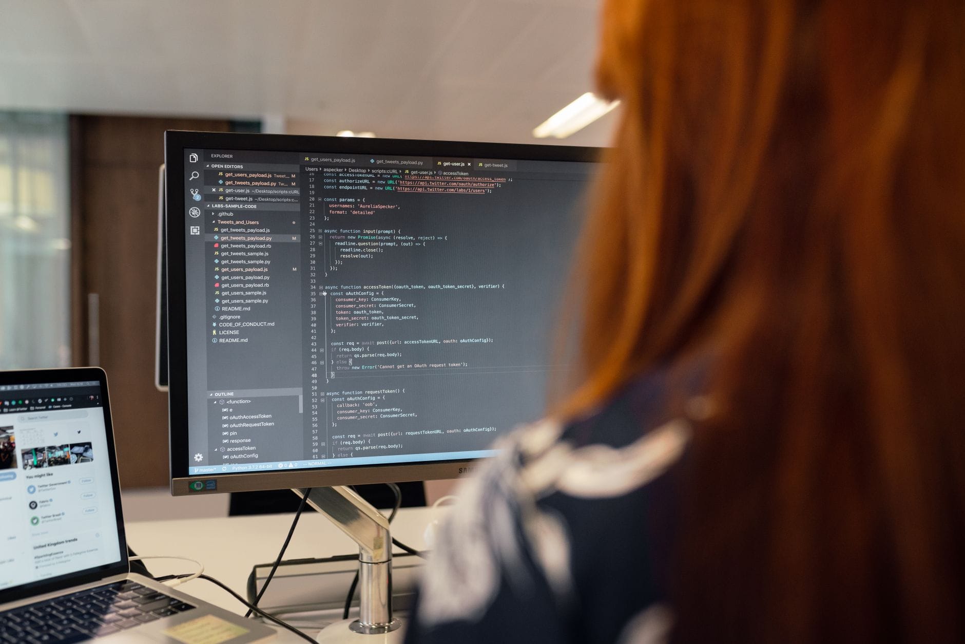 Kobieta programistka pisze kod PHP przy biurku w nowoczesnym biurze