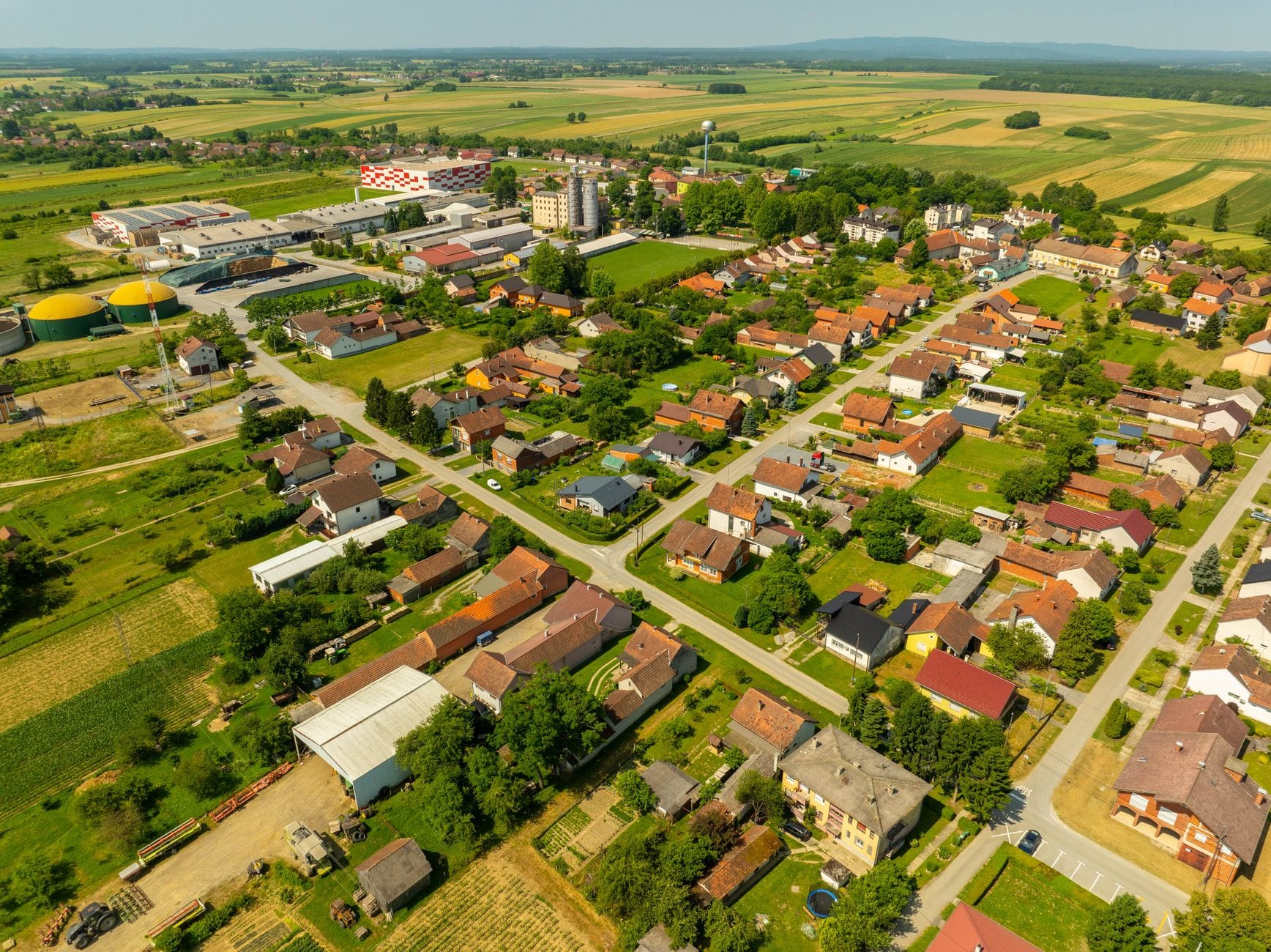 Panorama wsi z polami uprawnymi i zabudową rolniczą